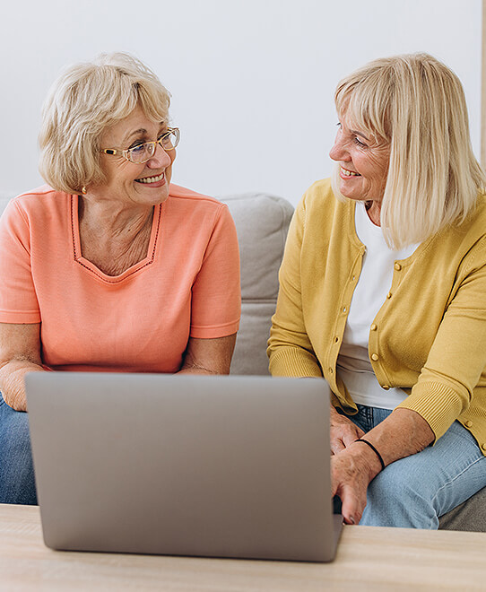 Two women behind a computer researching stoma support services