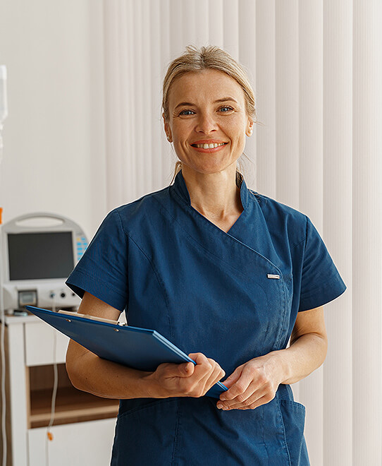 Stomal nurse smiles at the camera holding patient support documents